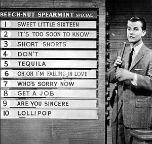 Late 1950s: Dick Clark reviewing weekly “top hits” during a segment of the American Bandstand TV show.
