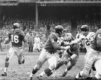 Frank Gifford (No. 16), New York Giants, running with ball against the Washington Redskins, Yankee Stadium, November 29, 1959.  Photo, Neil Leifer. 