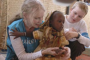 Mia Farrow became a UNICEF ambassador in 2000, shown here with her son, Ronan, looking on at right.