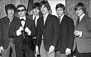 Phil Spector, in sunglasses, mid-1960s, with the Rolling Stones, having helped write at least one song on their debut album.