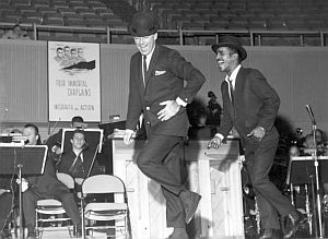 Feb 7, 1960: Peter Lawford & Sammy Davis, Jr. on stage at Four Chaplin’s Benefit, Las Vegas Convention Center.  Photo, University of Nevada, Las Vegas.