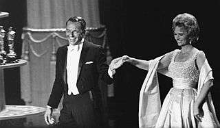 April 1963: Frank Sinatra hosts the Academy Awards ceremony, shown here escorting actress Donna Reed.
