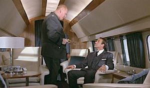 Mr. Goldfinger has his revolver trained on Bond while the plane is being hi-jacked.