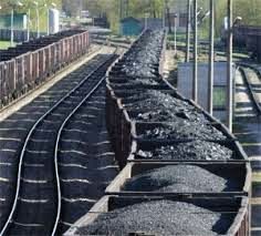 Long lines of coal hopper cars loaded with coal on rail siding.