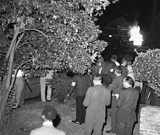 May 21, 1961: U.S. Marshals stand guard in front of Baptist Church as an automobile burns in the distance after being overturned by the mob. Photo, AP/Horace Cort 