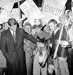 JFK, on a winter visit to Manchester, NH, greets student supporters at St. Anselm’s College who have brought along a donkey, symbol of the Democratic Party.  