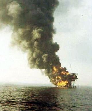 December 1970: Shell”s “Platform 26” burning in the Gulf of Mexico following well blow out.  Photo by Bob King aboard Coast Guard cutter, ‘Dependable,’ arriving at scene.