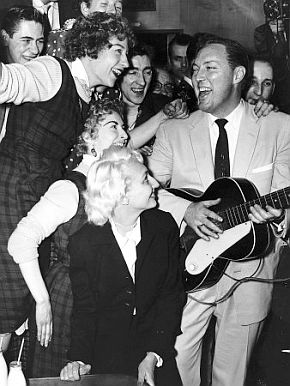 Feb 1957: U.K. fans mob Bill Haley and 2nd wife (bottom center) on train to Waterloo Station.
