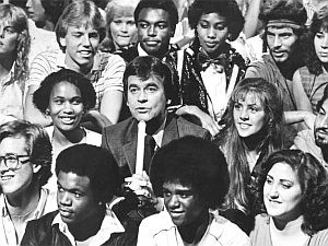 1981: Los Angeles Times photo of Dick Clark seated among show attendees in “Bandstand” bleachers as he introduces a guest act.