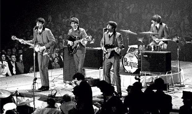 The Beatles performing at their  February 11, 1964 concert at the Washington Coliseum indoor arena in Washington, D.C.,  their first ever live U.S. concert performance. From left: Paul McCartney, George Harrison, John Lennon, and Ringo Starr on drums. 