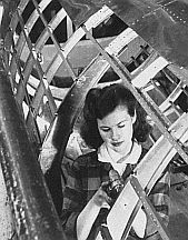 Woman working inside the tail of a B-17 aircraft at Boeing production line in Seattle, WA, 1940s.