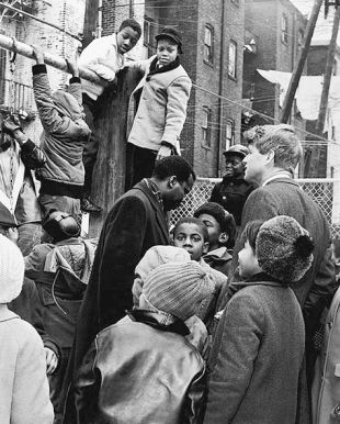 Photo of U.S. Senator Robert F. Kennedy and Donald F. Benjamin of the Central Brooklyn Coordinating Council surrounded by children in Bedford-Stuyvesant, Brooklyn, NY, Feb 5, 1966.  Photo Dick DeMarsico.
