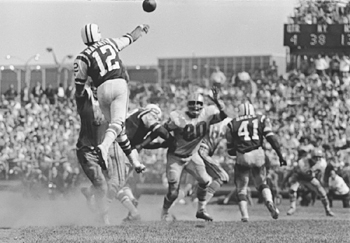 Joe Namath, leaping about 2 feet off the ground, throws a pass over the defensive line of the Houston Oilers at Shea Stadium, Sept. 18,1966. NYTimes/Barton Silverman.