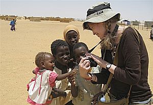Mia Farrow shows a photo to Sudanese children at a refugee camp in eastern Chad. August 5, 2008.