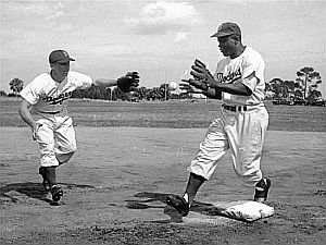 Pee Wee Reese & Jackie Robinson turning a double play during March 1950 spring training in Vero Beach, FL. Photo Phil Sandlin, AP.