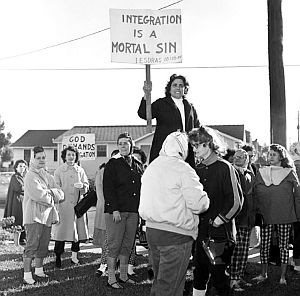 November 1960: Demonstrators during school integration in New Orleans, Louisiana;  one holding sign that reads, “Integration is A Mortal Sin.”