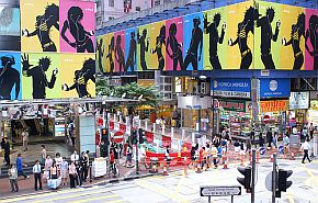 Aug 2005: Large posters of iPod dancers adorn buildings above shoppers in Hong Kong.