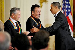 Actor Robert De Niro looks on as President Obama congratulates Bruce Springsteen as a Kennedy Center Honoree during a December 2009 White House ceremony.