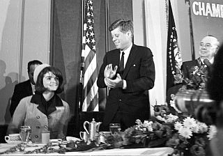President John F. Kennedy welcoming his wife, Jacqueline, to the head table in Forth Worth, Texas, November 22, 1963.