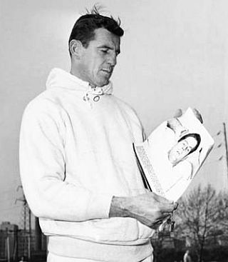 Nov 22, 1960: The Eagles' Chuck Bednarik, in light work-out clothes in Philadelphia, looks at an Associated Press photo of Frank Gifford holding an ice pack to his head in the hospital.