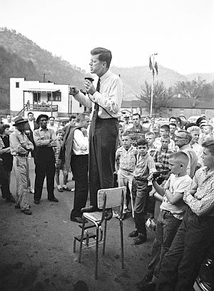 April 25, 1960: JFK campaigns in rural Logan County, West Virginia looking for support for the May 10th primary, precariously perched on a high-chair to deliver his speech. Photo, Hank Walker.