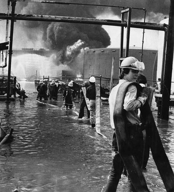August 1975: Firemen pulling hose through the Gulf Oil Refinery in Philadelphia, PA, on their way to do battle with the fierce blaze.  Note accumulating water at their feet.  Dominic Ligato, Philadelphia Evening Bulletin photo /Temple Univ. 