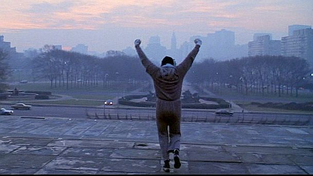In one of the “Rocky” film’s most iconic screen moments, Bill Conti’s composition of the theme song, "Gonna Fly Now" reaches a crescendo point as Rocky now sprints to the top of the Art Museum’s fabled steps, where he proceeds to do a little “champ dance,” proclaiming his fitness with arms raised while facing a Philadelphia morning skyline. Click for similar poster.