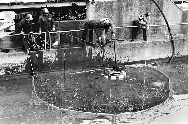 January 1988: Following the Ashland Oil tank collapse, which polluted the Monongahela and Ohio rivers, workers on the Monongahela at the Braddock Lock, attempt to remove oil from the river. Tony Tye/ Pittsburgh Post-Gazette.
