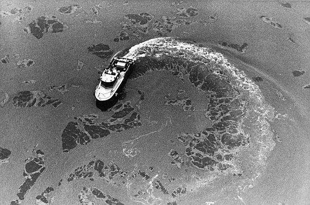 January 1988: Boat on the Monongahela River in the aftermath of the Ashland Oil tank collapse. The “dark patches” in this case are those of water, the rest is spill. Photo, Pittsburgh Post-Gazette