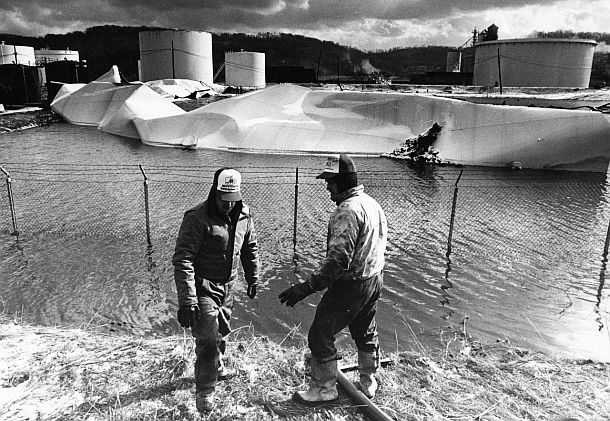 January 1988: Workers at Ashland’s Floreffe, PA storage yard in aftermath of tank collapse, try to clean up some remains of spilled diesel fuel in an earthen-bermed containment area. Photo, Darrell Sapp/Pittsburgh Post-Gazette.