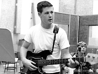 A young Brian Wilson, in real life, early 1960s, in a studio setting with fellow Beach Boy, David Marks behind him, lower right.