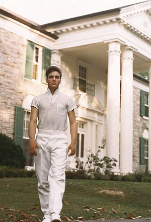1957: Elvis at front entrance of Graceland mansion.