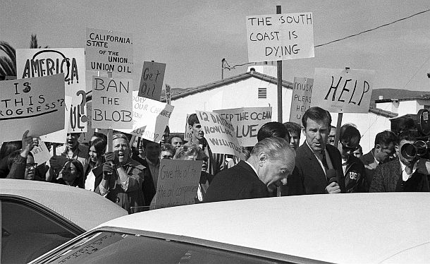 Feb 7th, 1969: Union Oil president Fred Hartley, foreground, backs away from a TV reporter after having words with him in Santa Barbara, CA. Hartley, on arrival at the airport, unexpectedly ran into crowd of hostile pickets angry about the oil spill. Pickets were then waiting for Sen. Edmund Muskie. Harold Filan / AP photo. 