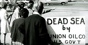 1969: Santa Barbara citizen displays his "dead sea" placard during oil spill protest gathering.