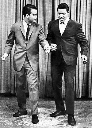 1960. Dick Clark of American Bandstand receiving instruc-tions from Chubby Checker on how to do The Twist.