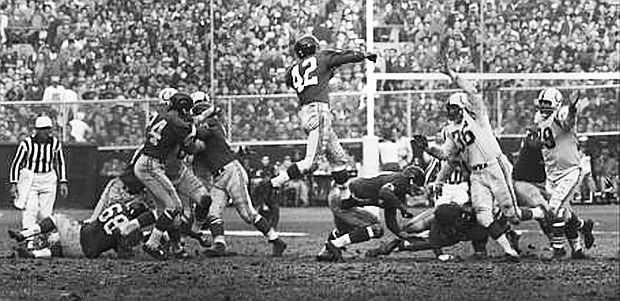 Earlier in the game, Giants quarterback, Charlie Conerly (42), had been having a pretty good day, shown here throwing a jump pass over on-rushing Colt defenders. But in the overtime period, the Giants seemed to run out of gas.